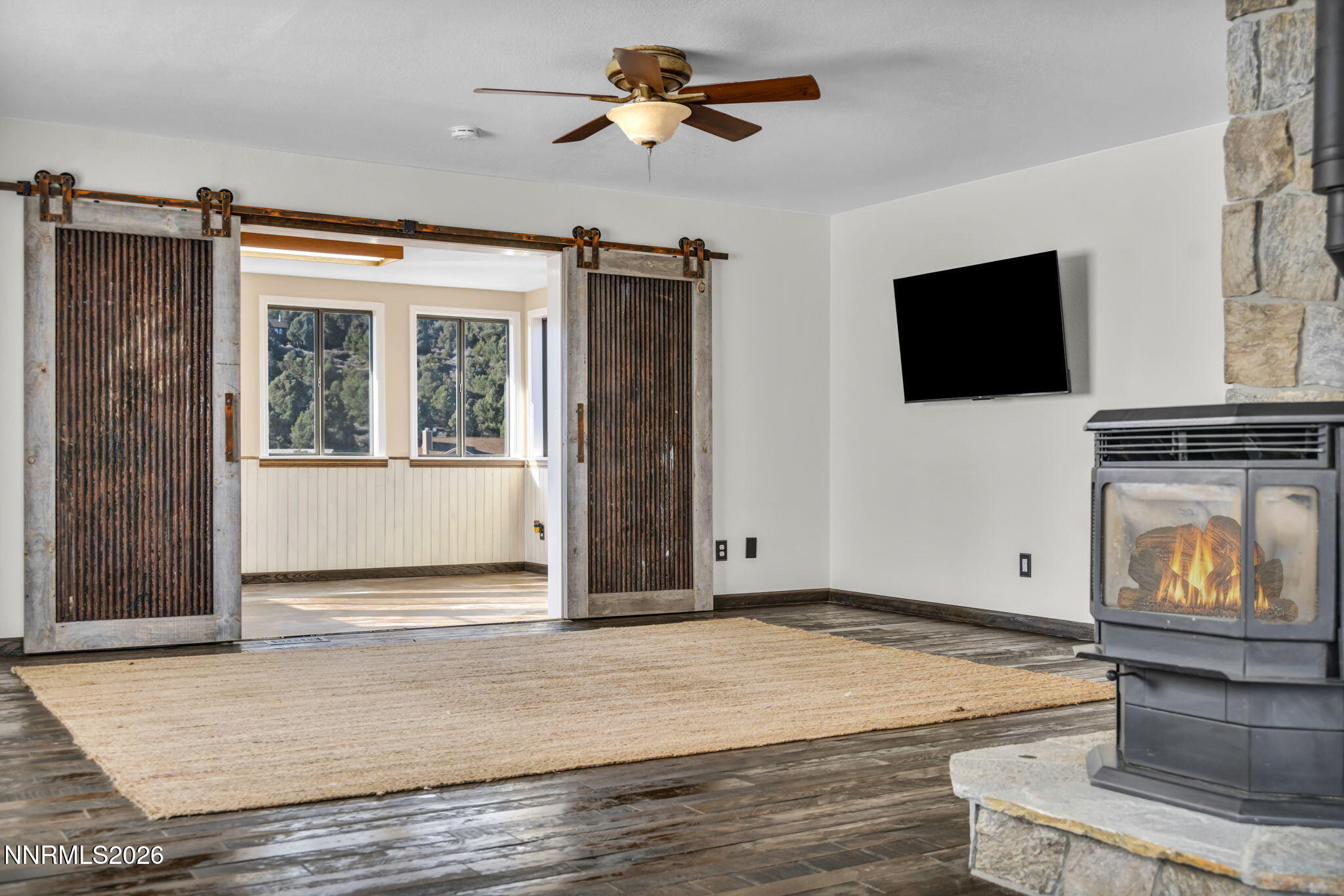 1835 Lousetown Road Reno, NV 89521 - Photo 24 of 60 a view of a livingroom with a fireplace a chandelier fan and wooden floor