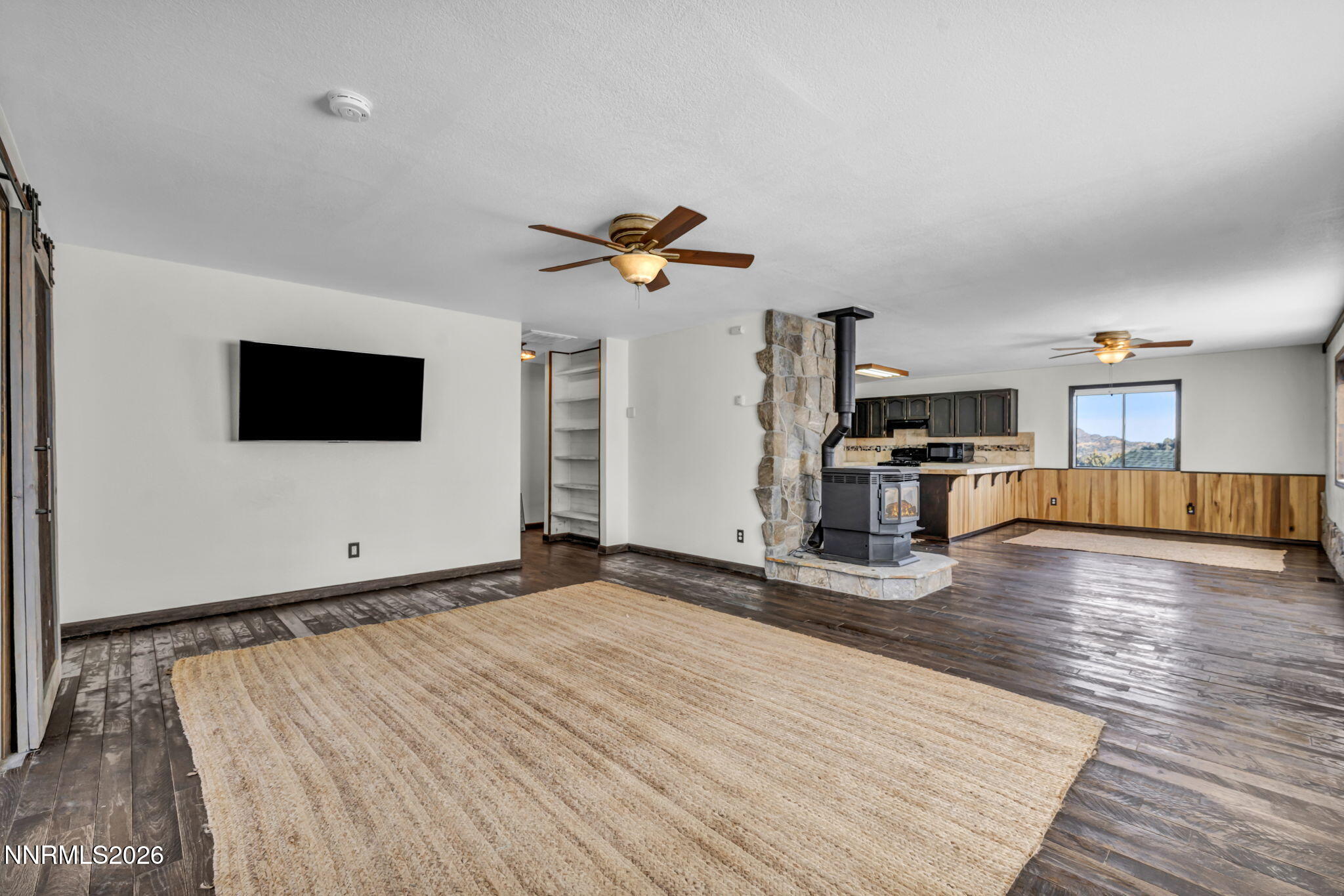 1835 Lousetown Road Reno, NV 89521 - Photo 25 of 60 a view of a livingroom with a flat screen tv wooden floor and a ceiling fan