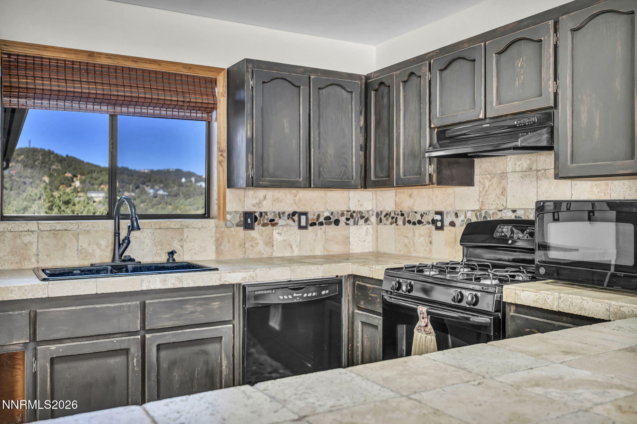 1835 Lousetown Road Reno, NV 89521 - Photo 37 of 60 a kitchen with stainless steel appliances granite countertop a stove a sink and a microwave