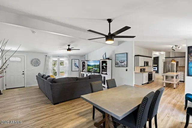 a living room with furniture a flat screen tv and a wooden floor