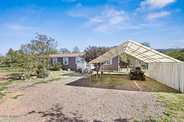 a view of a house with a yard and large trees