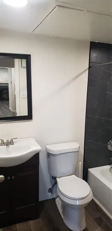 a bathroom with a toilet a sink and mirror