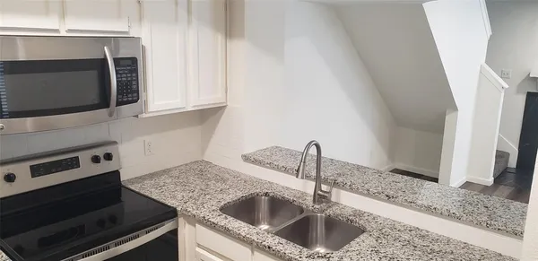 a kitchen with a sink and a stove top oven