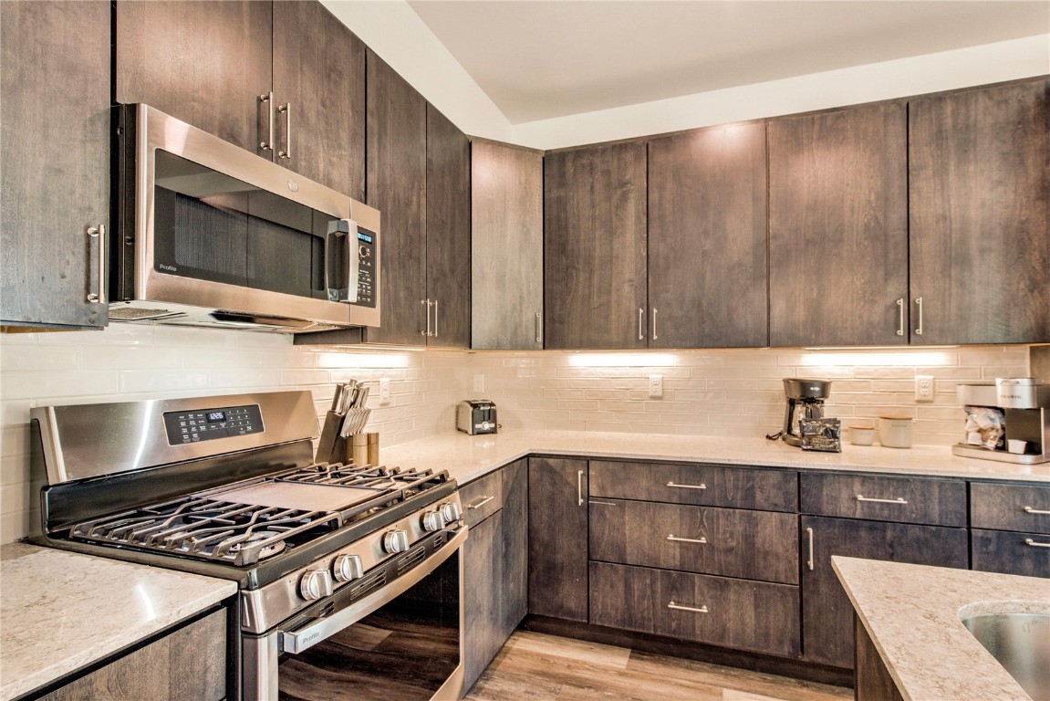 596 Fly Line Drive Silverthorne, CO 80498 - Photo 8 of 32 a kitchen with wooden cabinets and a stove top oven