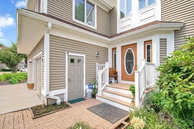 a front view of a house with a garden and plants