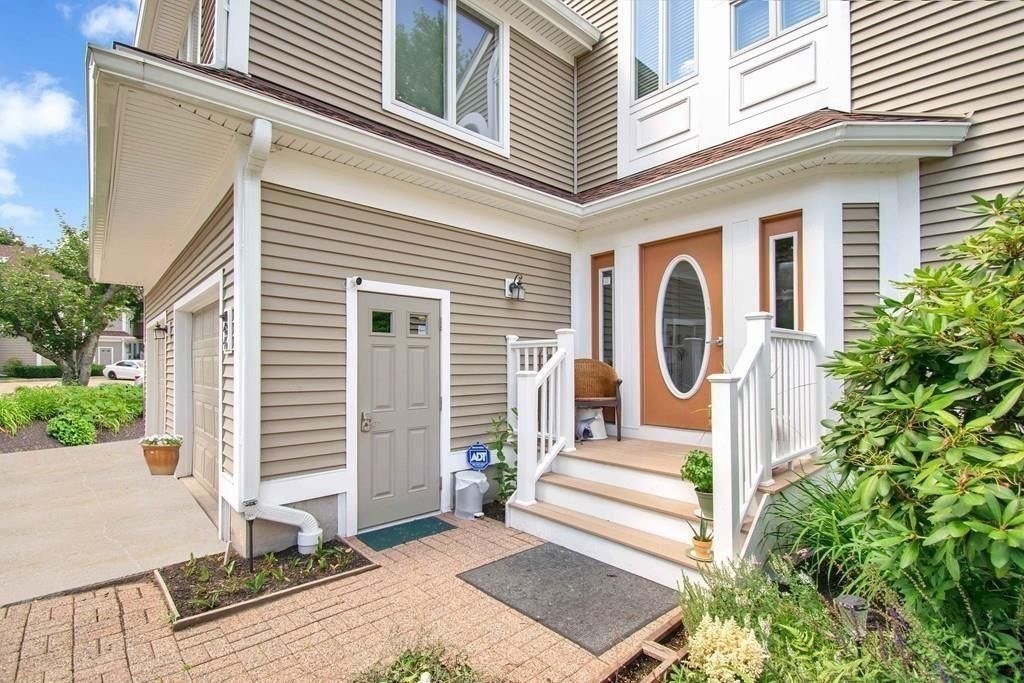 a front view of a house with a garden and plants