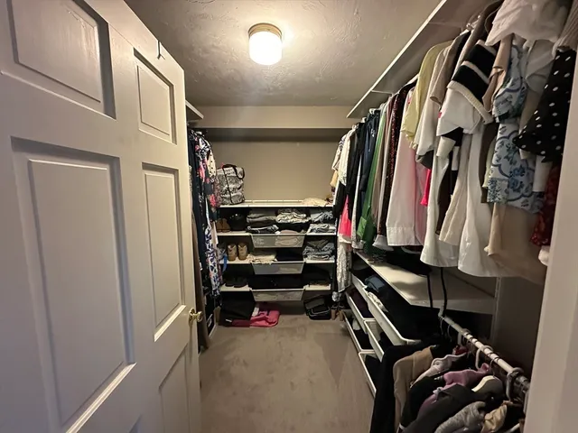 a view of walk in closet with clothes and shoes