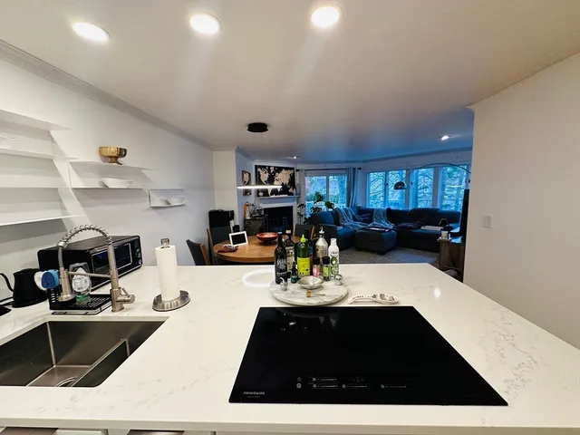a kitchen with sink and view of living room