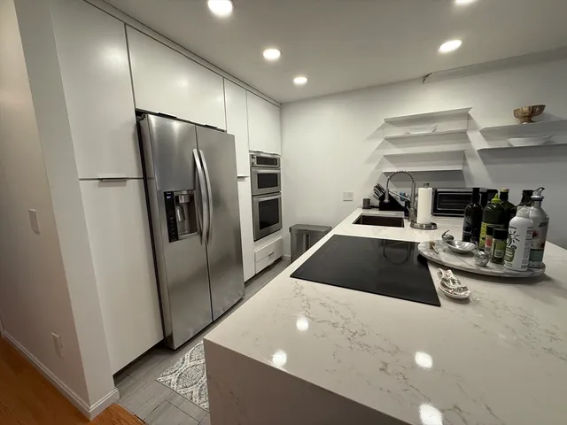 a kitchen with stainless steel appliances a refrigerator and trees