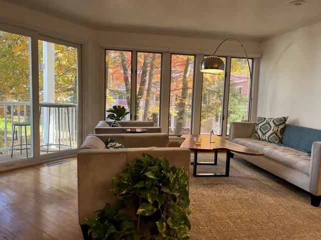 a living room with furniture and floor to ceiling windows