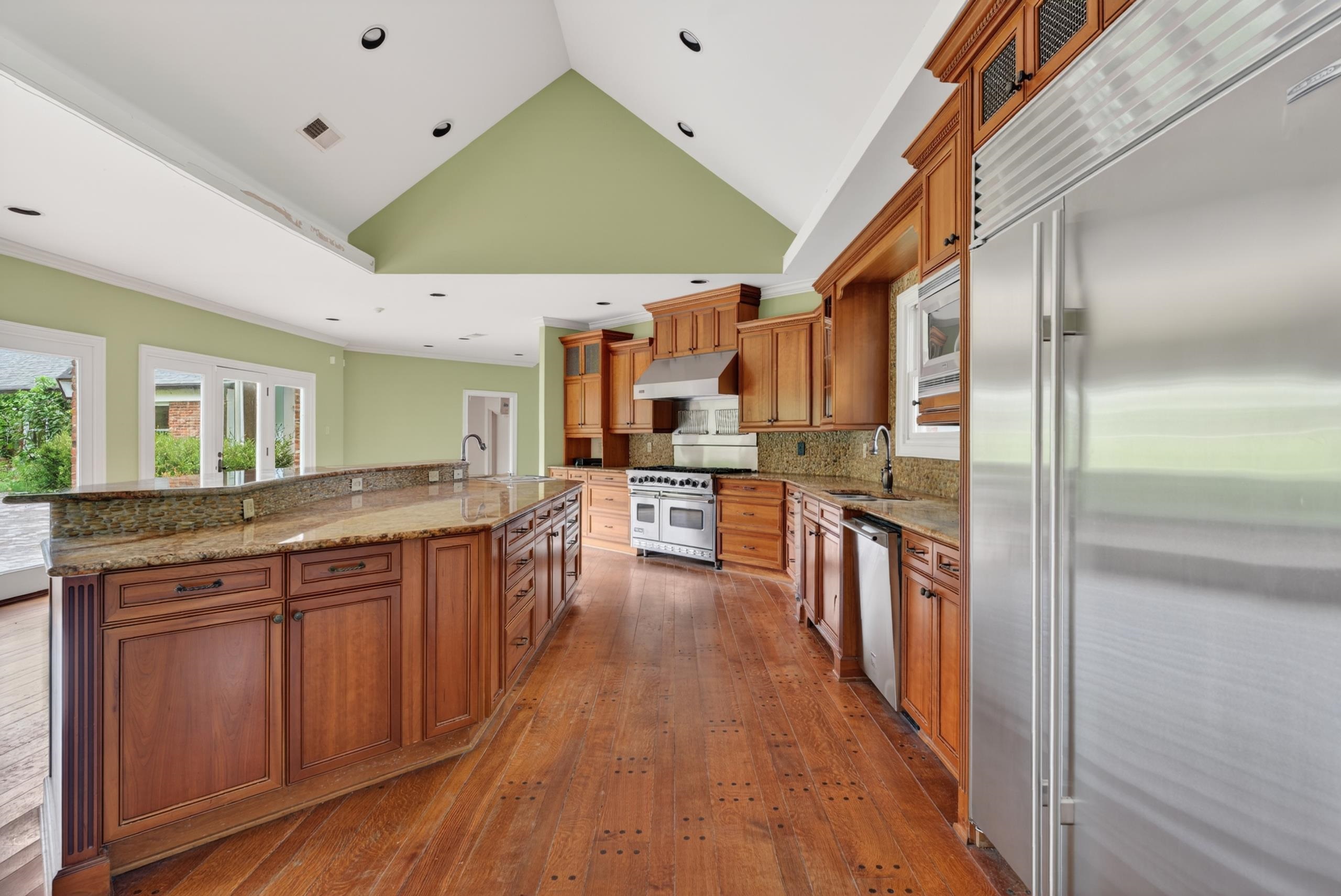 530 West Raines Road Memphis, TN 38109 - Photo 13 of 38 Spacious kitchen featuring an expansive center island with a raised breakfast bar, wood-finish flooring, and recessed lighting