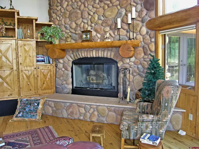 a stone wall with a fireplace and a wooden floor