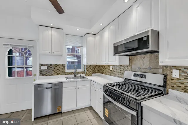 a kitchen with stainless steel appliances granite countertop a stove and a sink