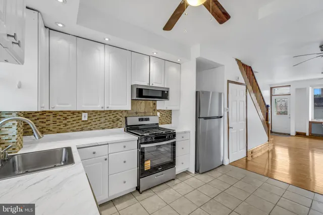 a kitchen with white cabinets and black stainless steel appliances