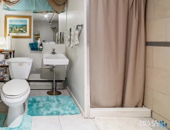 a bathroom with a sink a toilet a mirror and shower