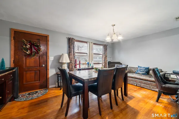 a dining room with furniture a chandelier and wooden floor