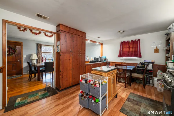 a living room with furniture and a dining table with wooden floor