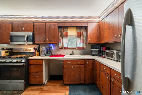 a kitchen with stainless steel appliances granite countertop a stove a sink and a microwave