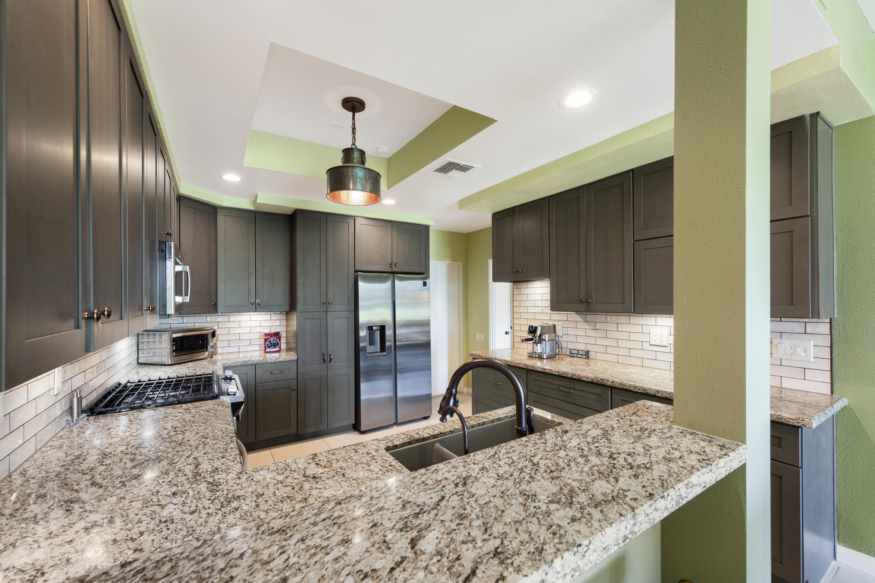 836 Inverness Drive Rancho Mirage, CA 92270 - Photo 7 of 29 a kitchen with stainless steel appliances kitchen island granite countertop a sink stove and refrigerator