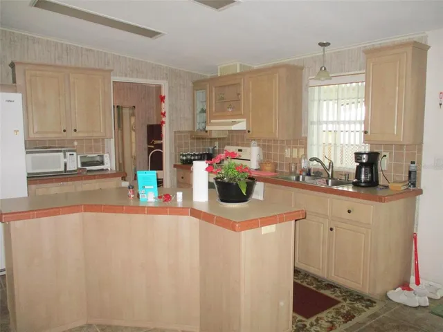 a kitchen with stainless steel appliances a sink window and cabinets