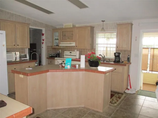 a kitchen with stainless steel appliances a refrigerator a sink a stove a microwave a counter top space and cabinets