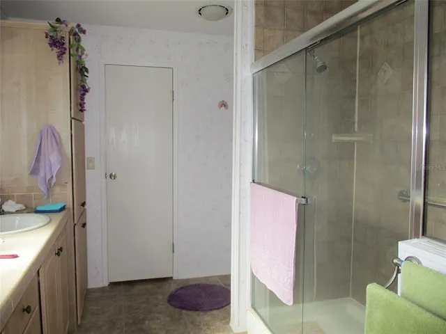 a bathroom with a granite countertop shower and a sink
