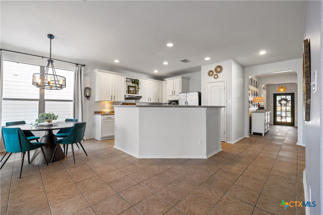 723 Tumbleweed Trail Temple, TX 76502 - Photo 12 of 38 a kitchen with a dining table chairs and refrigerator