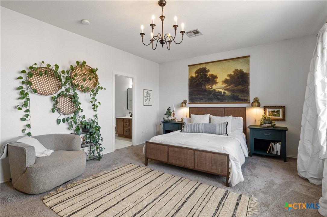 723 Tumbleweed Trail Temple, TX 76502 - Photo 17 of 38 a bedroom with a bed and a chandelier