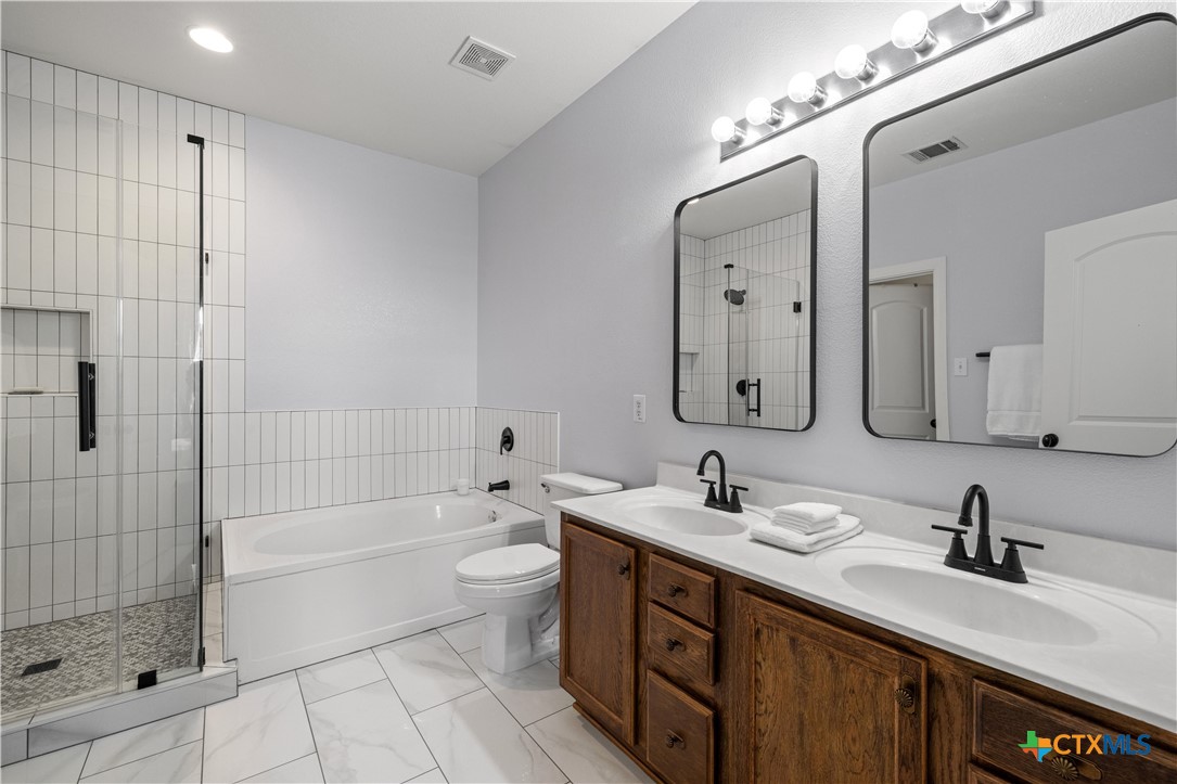 723 Tumbleweed Trail Temple, TX 76502 - Photo 19 of 38 a bathroom with a double vanity sink mirror double shower and a bathtub