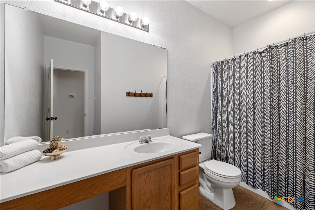 723 Tumbleweed Trail Temple, TX 76502 - Photo 22 of 38 a bathroom with a granite countertop sink toilet and mirror