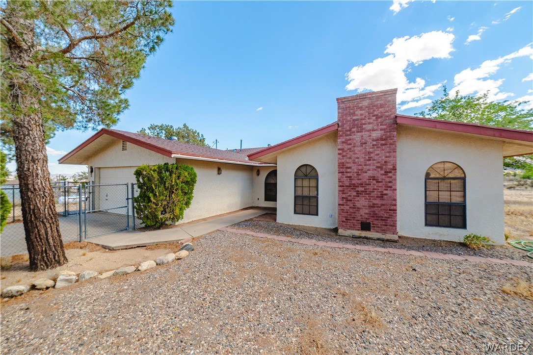 2100 East Valley View Road Kingman, AZ 86409 - Photo 1 of 53 Southwestern style residence featuring a stucco exterior and a contrasting red brick chimney