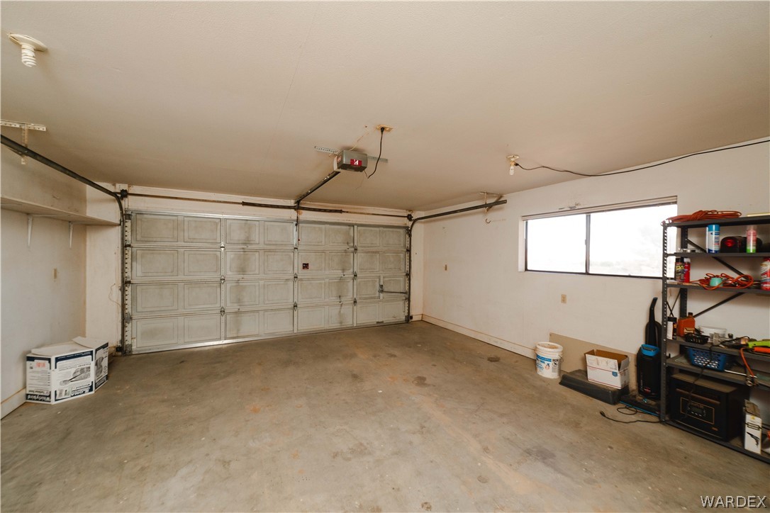 2100 East Valley View Road Kingman, AZ 86409 - Photo 35 of 53 Spacious garage featuring a paneled overhead door, concrete flooring, and an elevated window