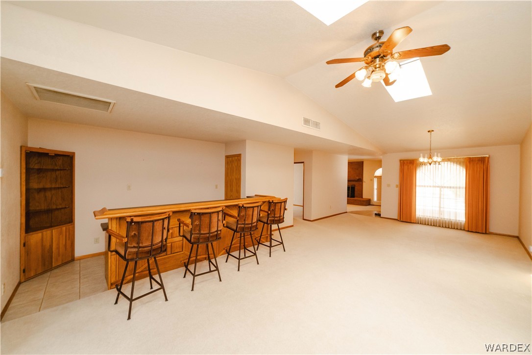 2100 East Valley View Road Kingman, AZ 86409 - Photo 10 of 53 Spacious interior featuring a built-in wooden wet bar, vaulted ceilings, and skylights