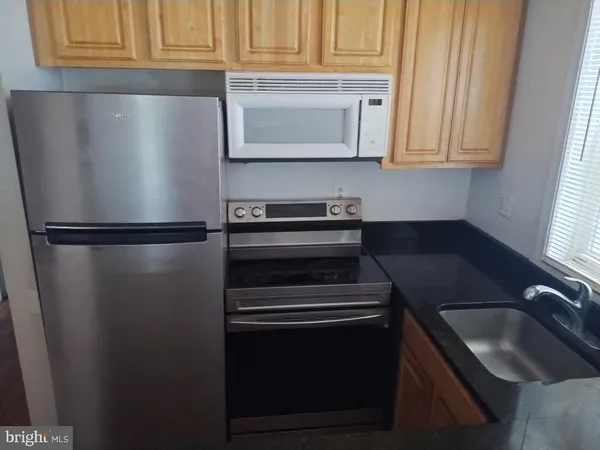 a kitchen with granite countertop stainless steel appliances and refrigerator