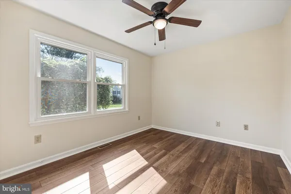 an empty room with a window and a ceiling fan