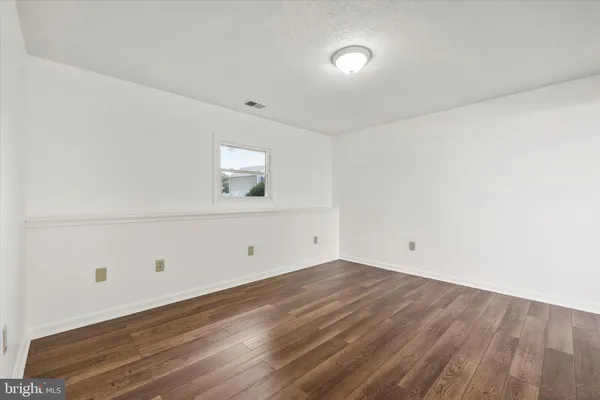 a view of a room with wooden floor and white walls