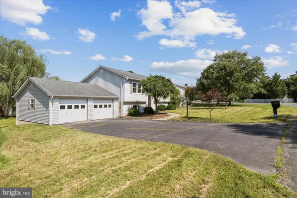a view of a house with a big yard and a large tree