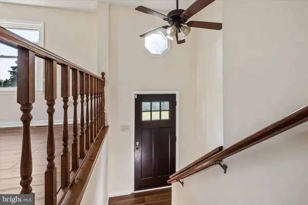 a view of staircase with wooden floor and fan