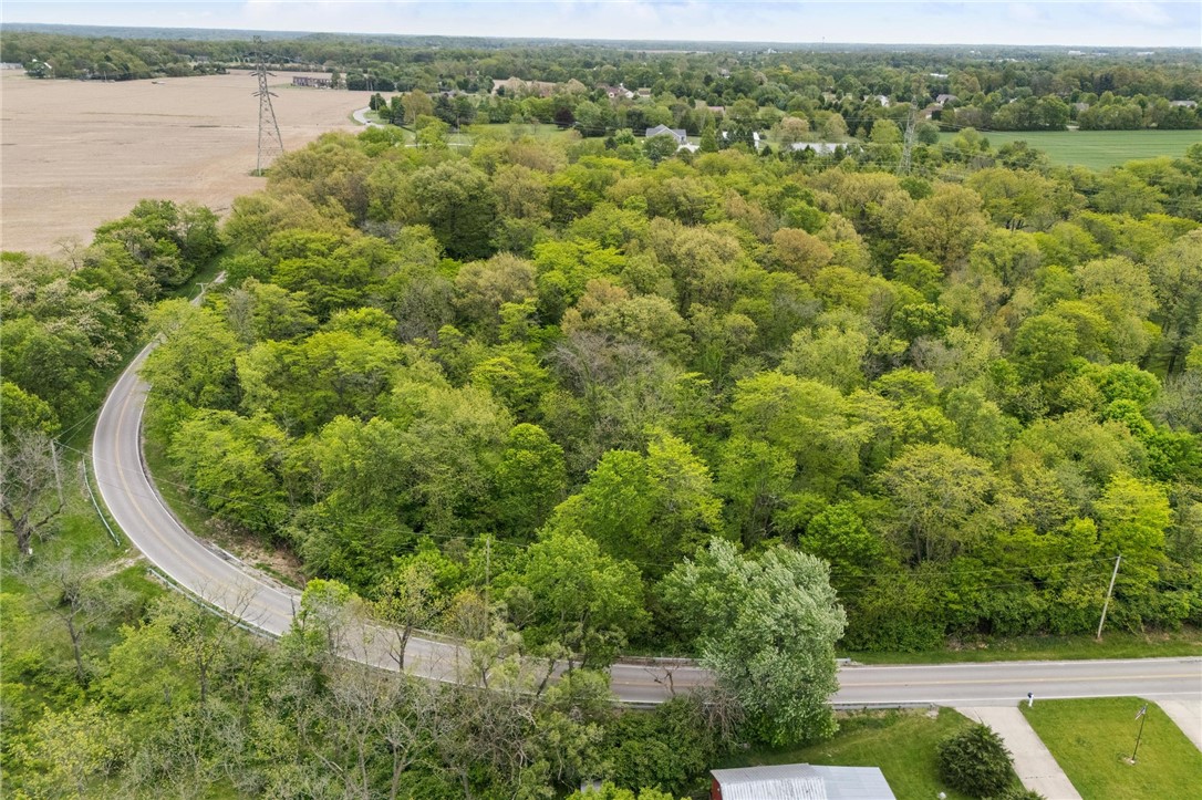 1940 Armstrong Road Fairborn, OH 45324 - Photo 44 of 48 Aerial view of lush green trees, roads, and open fields, offering a tranquil natural setting.