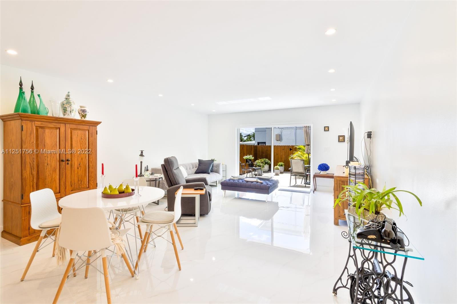 9076 Harding Avenue Surfside, FL 33154 - Photo 1 of 37 a living room with furniture and a dining table with garden view