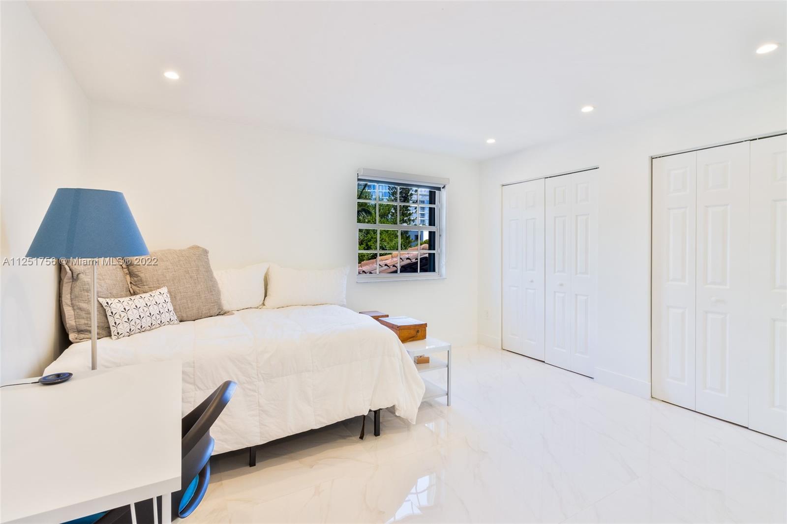 9076 Harding Avenue Surfside, FL 33154 - Photo 15 of 37 a bedroom with a bed and a lamp