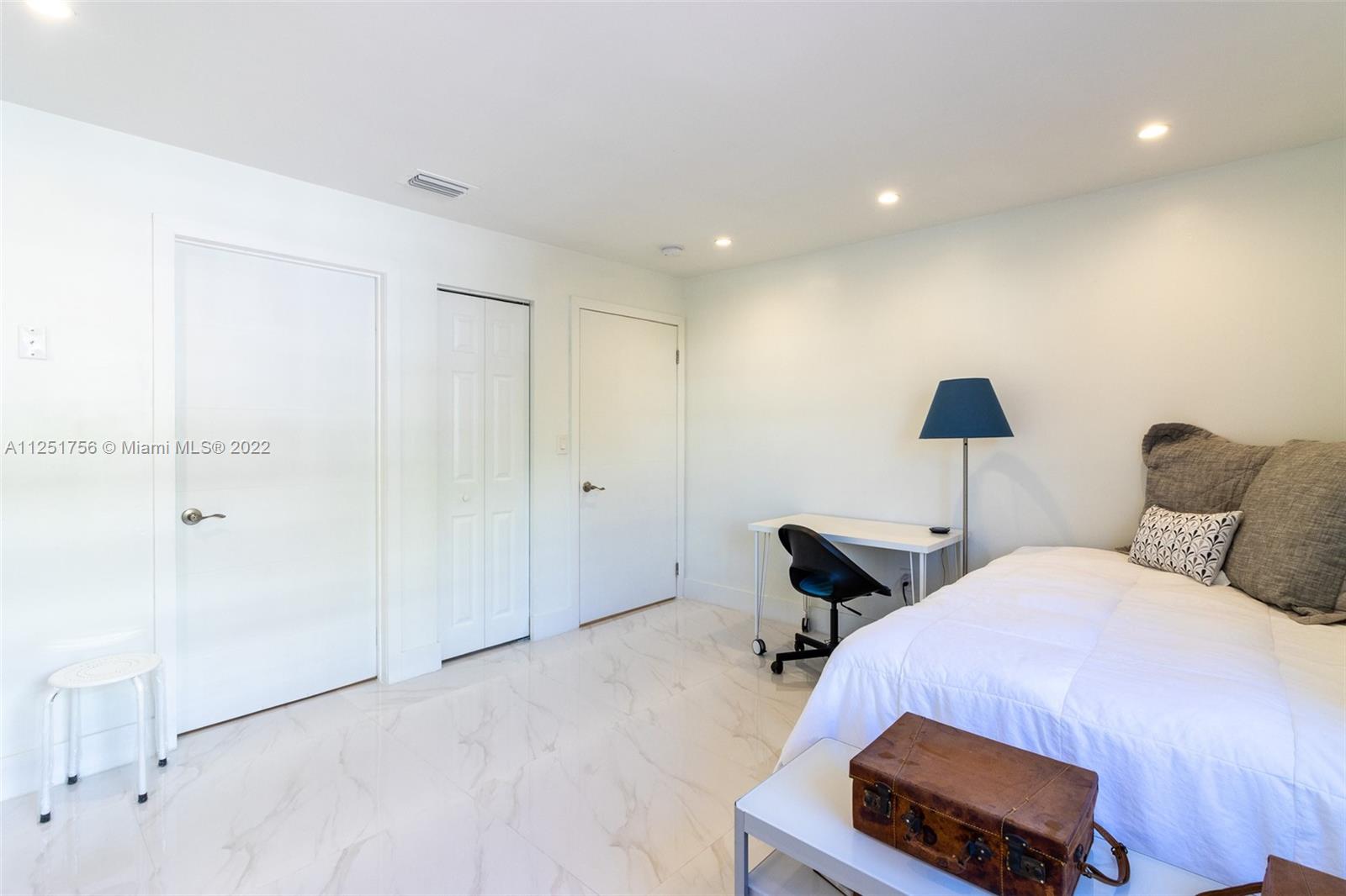 9076 Harding Avenue Surfside, FL 33154 - Photo 16 of 37 a bedroom with a bed and a night stand