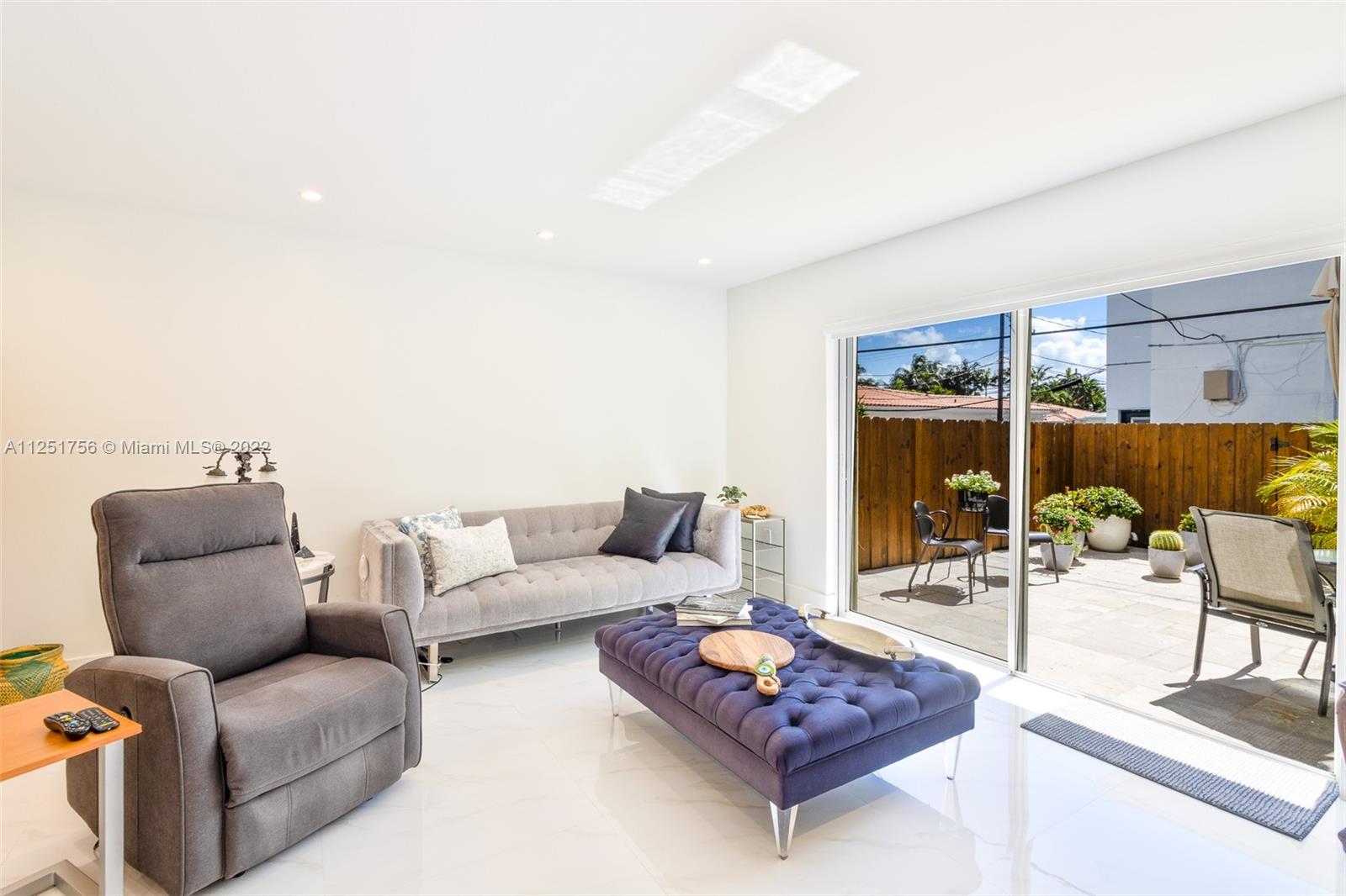 9076 Harding Avenue Surfside, FL 33154 - Photo 3 of 37 a living room with furniture and a floor to ceiling window