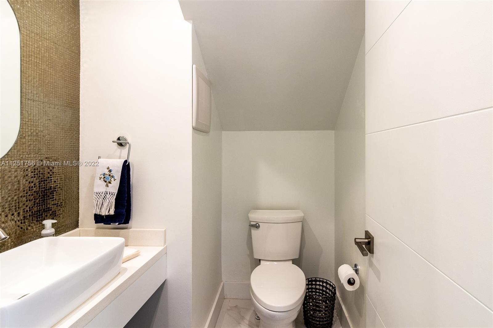 9076 Harding Avenue Surfside, FL 33154 - Photo 7 of 37 a bathroom with a granite countertop toilet and a sink