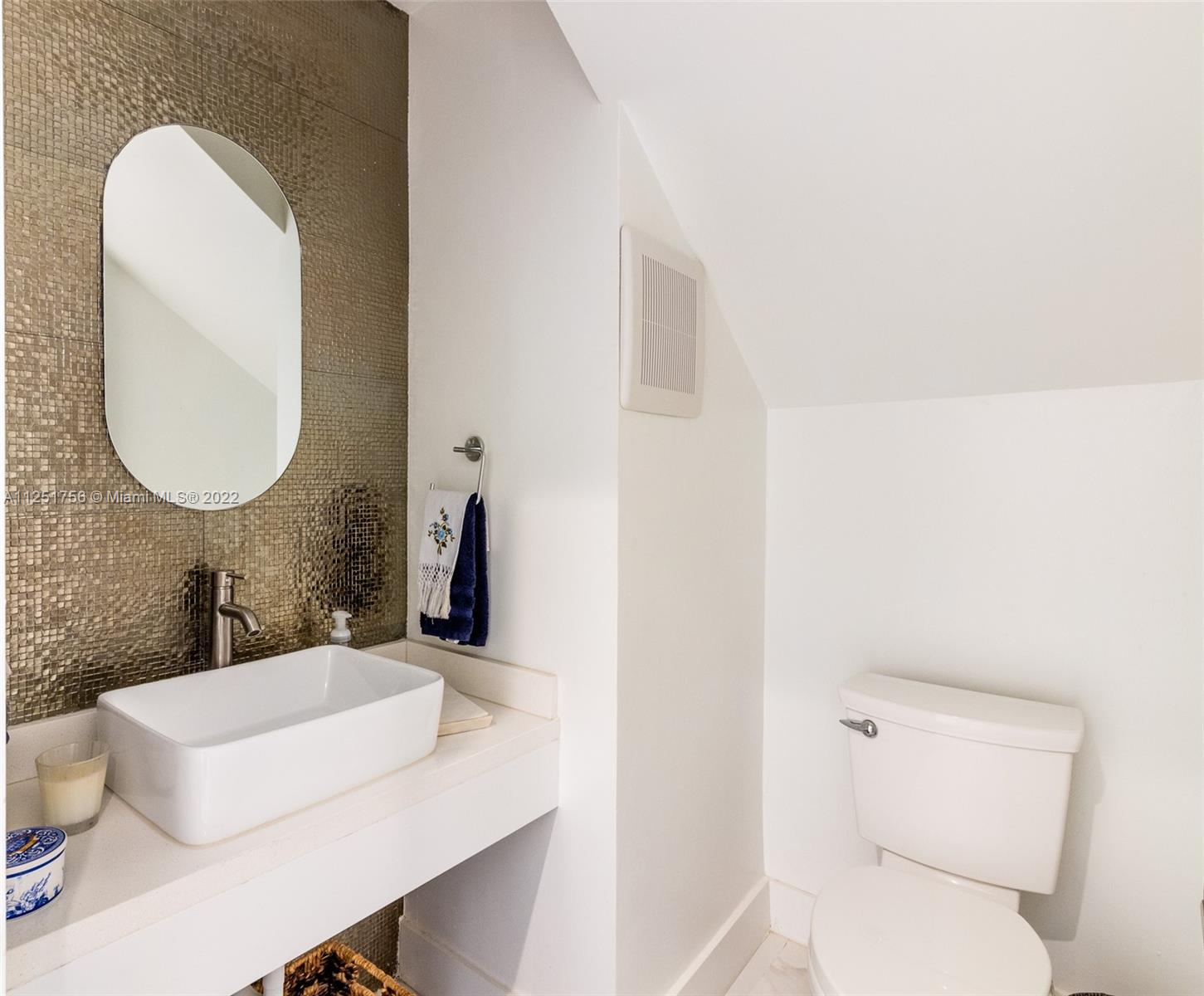 9076 Harding Avenue Surfside, FL 33154 - Photo 8 of 37 a bathroom with a toilet sink and mirror