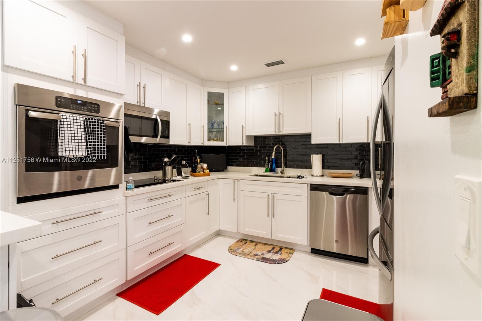 9076 Harding Avenue Surfside, FL 33154 - Photo 9 of 37 a kitchen with stainless steel appliances kitchen island granite countertop a refrigerator and cabinets