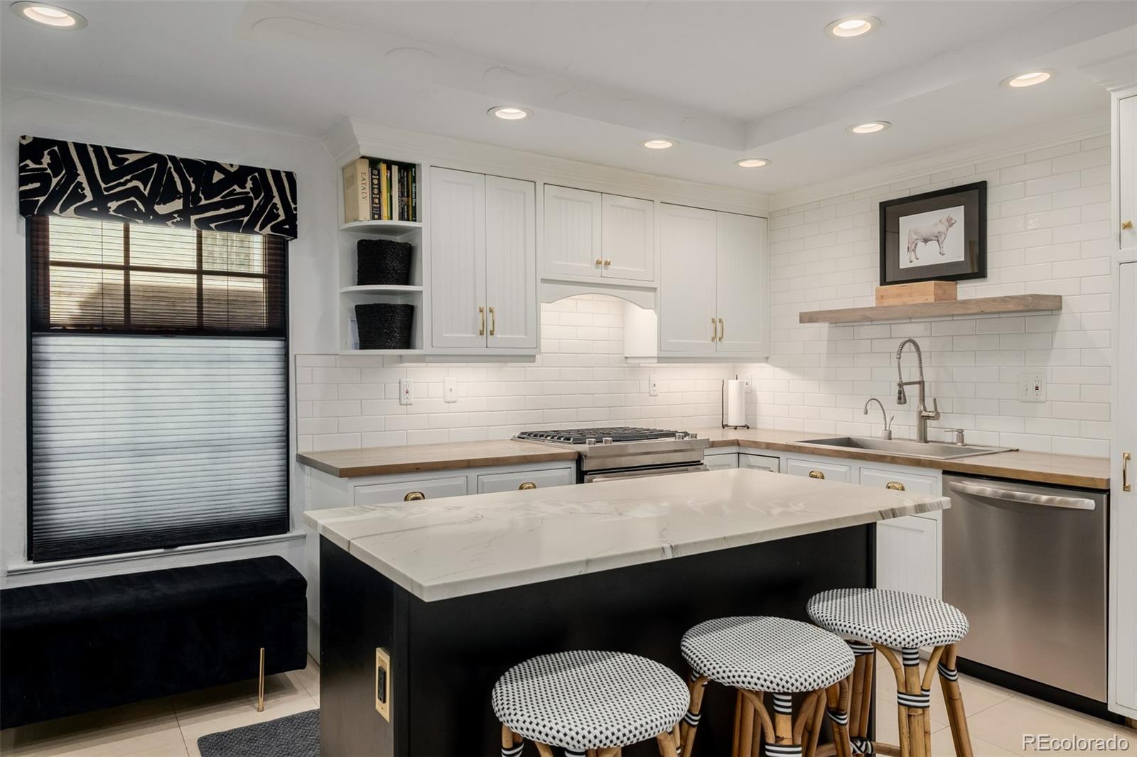 353 Bellaire Street Denver, CO 80220 - Photo 19 of 50 a kitchen with a sink a stove a microwave and cabinets