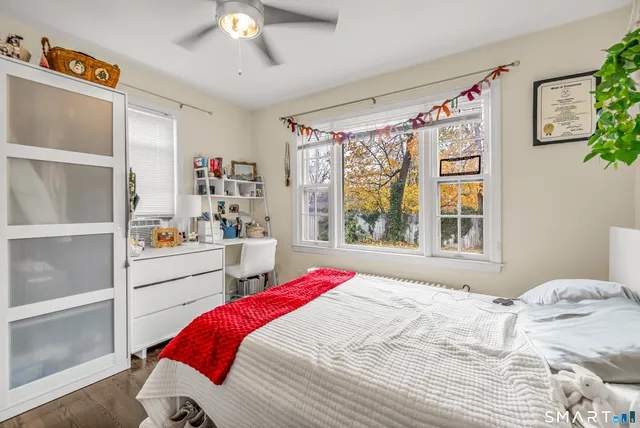 a bedroom with a bed and a large window with the outer view