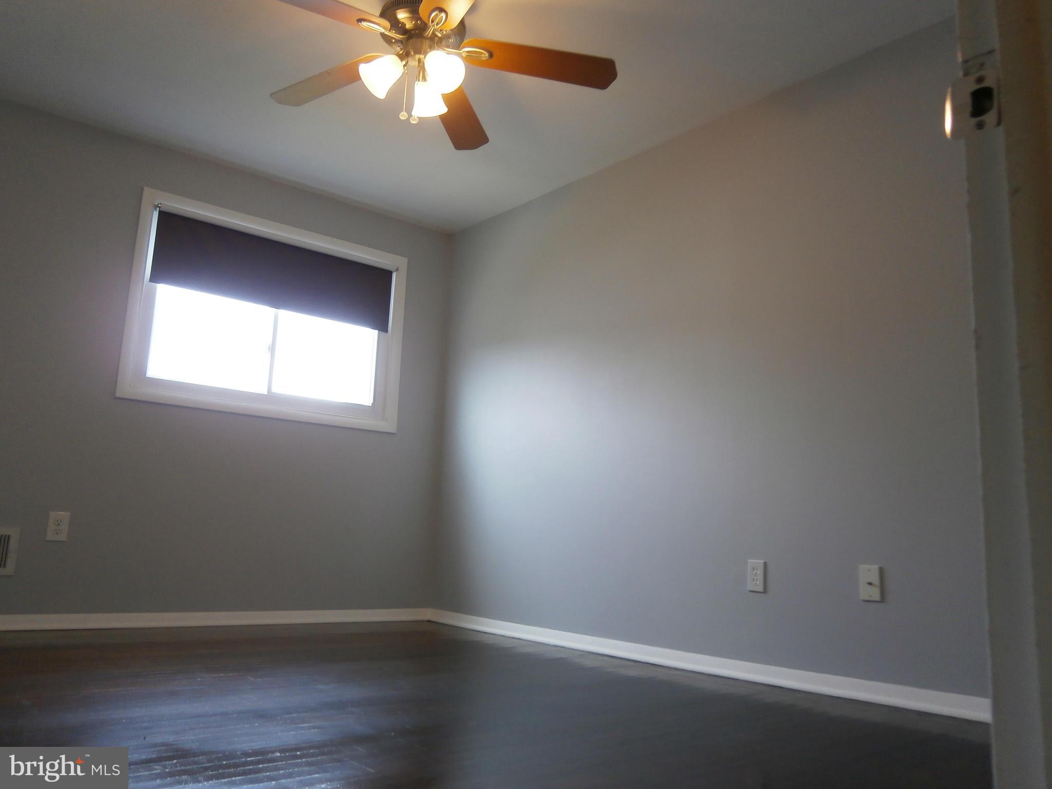 5636 Whitby Road Baltimore, MD 21206 - Photo 7 of 17 an empty room with wooden floor and windows