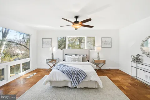 a bedroom with a bed and a large window